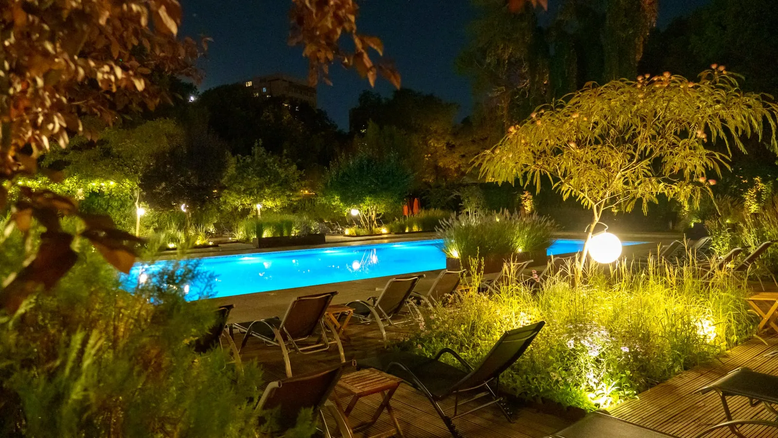Grădina și piscina luminate noaptea
